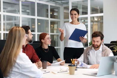 Photo of Team of employees working together in office