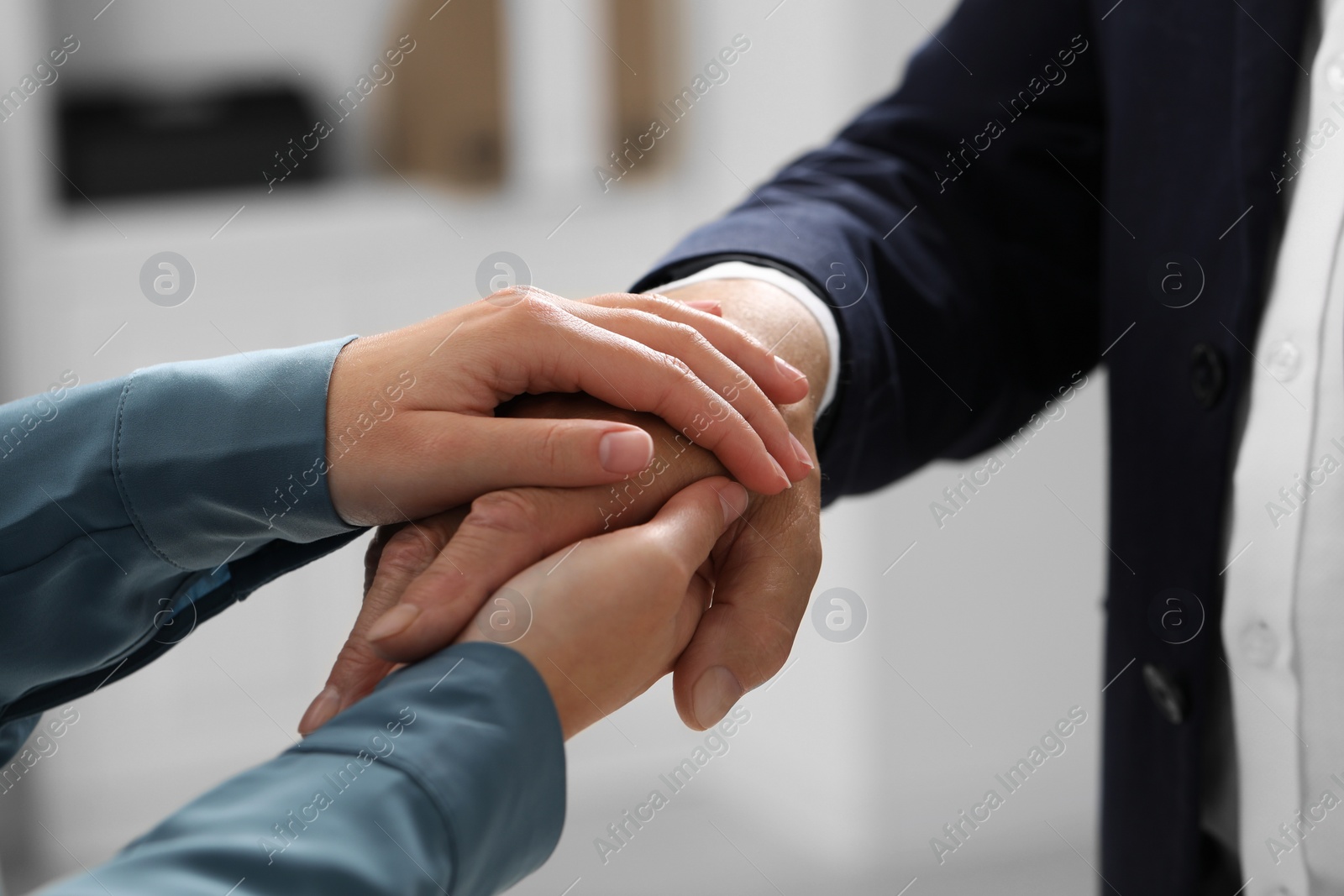 Photo of Trust and deal. Man with woman joining hands indoors, closeup