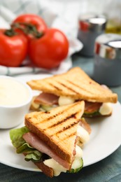 Photo of Delicious sandwiches with vegetables, ham and mayonnaise on plate, closeup