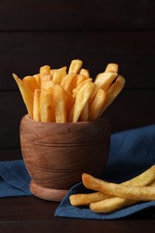 Bowl of tasty french fries on black table