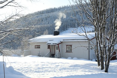 Photo of Beautiful view of house, snowy trees and bushes outdoors. Winter landscape