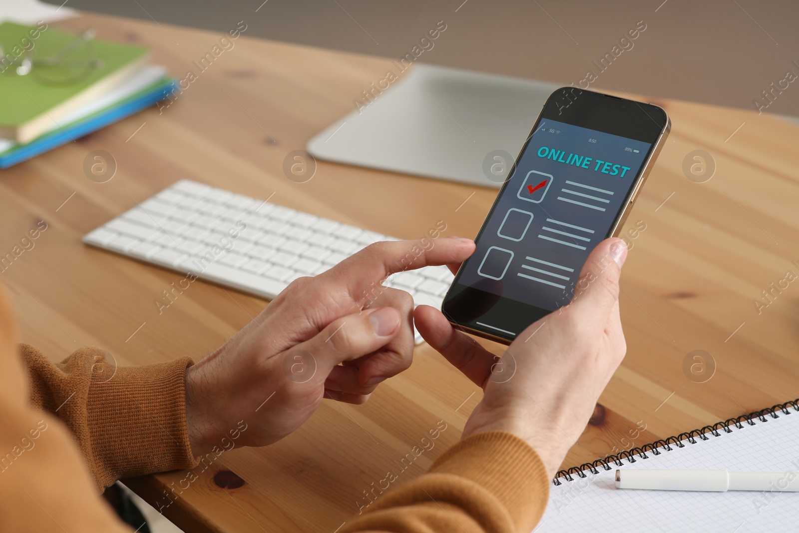 Photo of Man taking online test on smartphone at desk, closeup