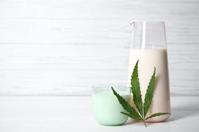 Photo of Glass and jug with hemp milk on white table