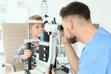 Photo of Ophthalmologist examining little boy in clinic