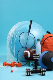 Photo of Many different sports equipment on light blue background