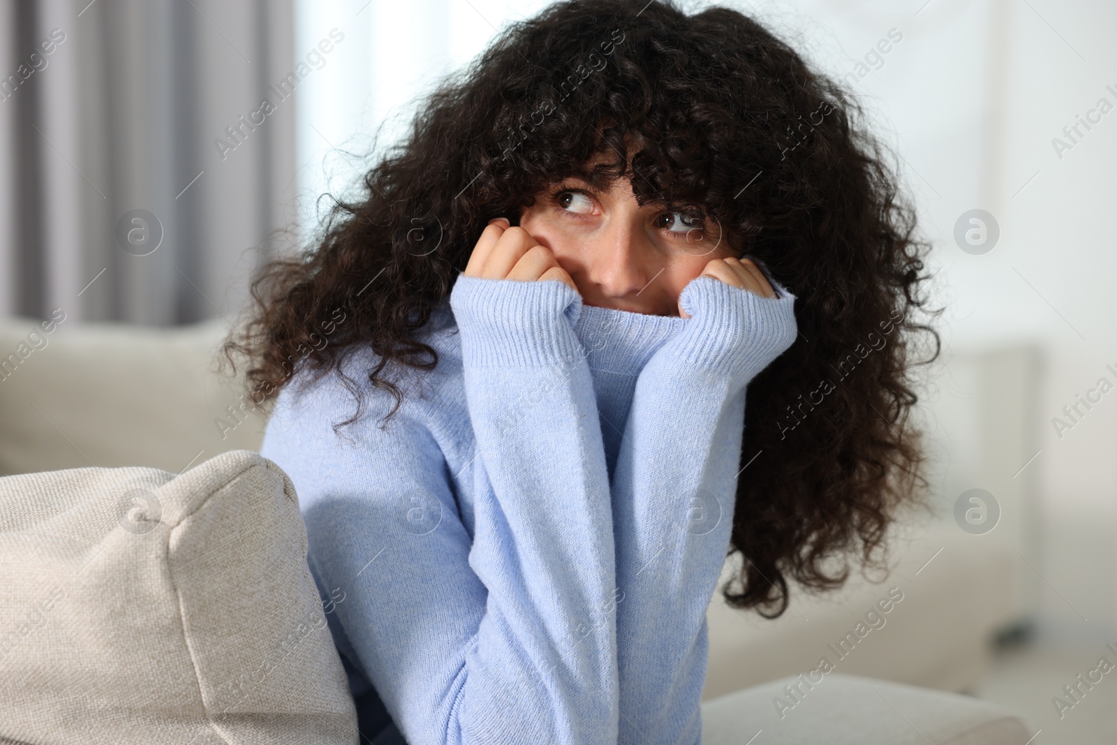 Photo of Young woman in stylish light blue sweater indoors