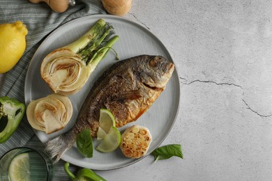 Delicious dorado fish with vegetables served on light grey table, flat lay. Space for text