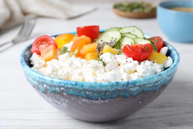 Photo of Delicious cottage cheese with vegetables and chia seeds served for breakfast on white wooden table, closeup