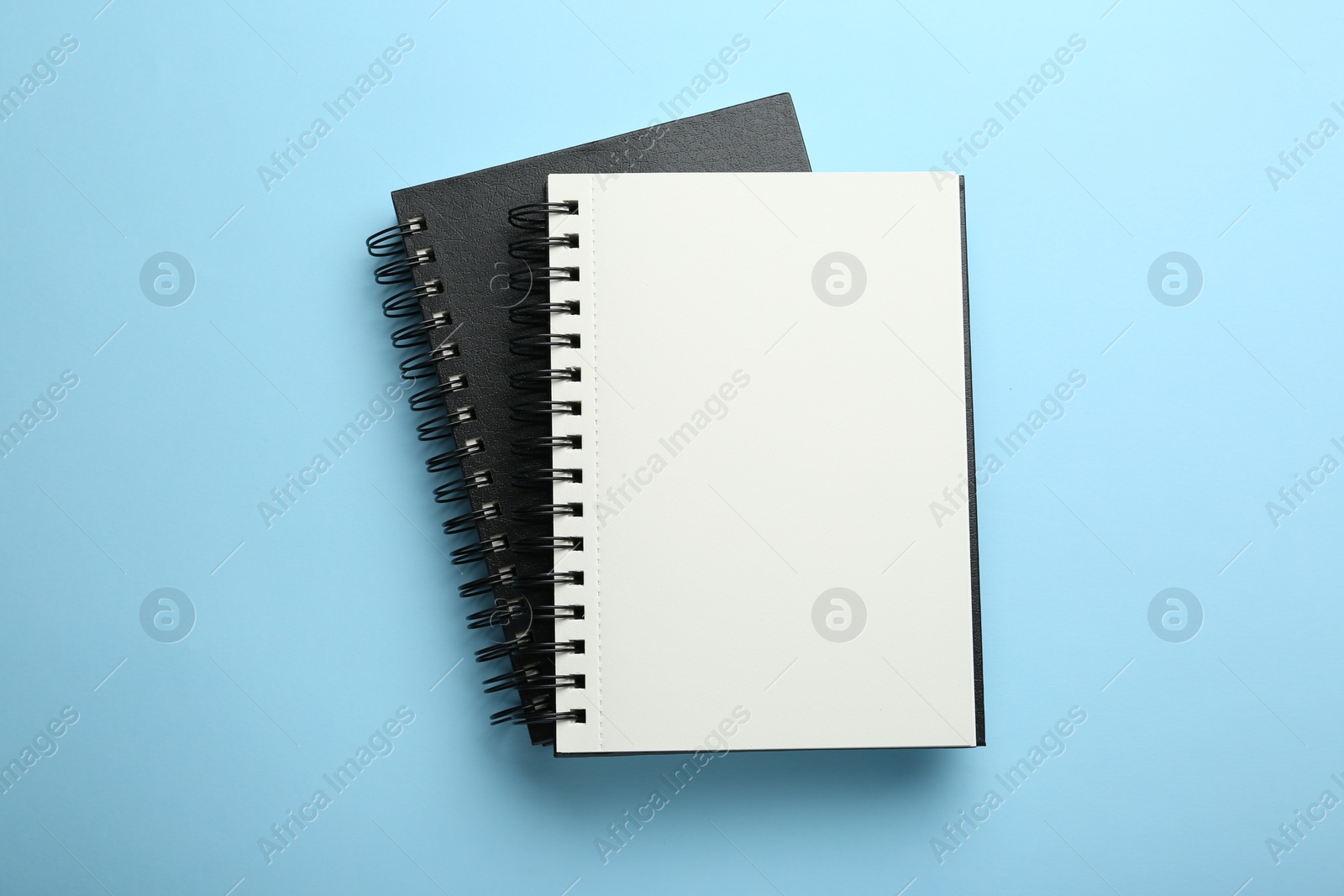 Photo of Notebooks on black background, top view. Space for text