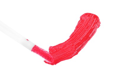 Photo of Stroke of red lip gloss and applicator isolated on white, top view