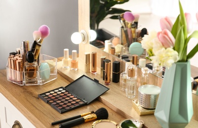 Photo of Dressing table with set of luxury cosmetic products. Interior element