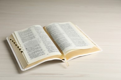 Photo of Open Bible on white wooden table. Christian religious book
