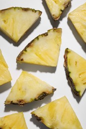 Pieces of tasty ripe pineapple on white background, flat lay