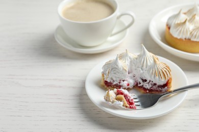 Photo of Tartlet with meringue served on white wooden table, space for text