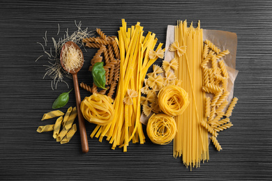 Photo of Flat lay composition with different types of pasta on black table