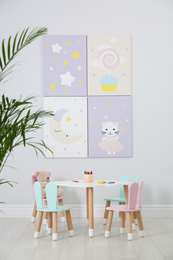 Photo of Little table and chairs with bunny ears in children's room. Interior design