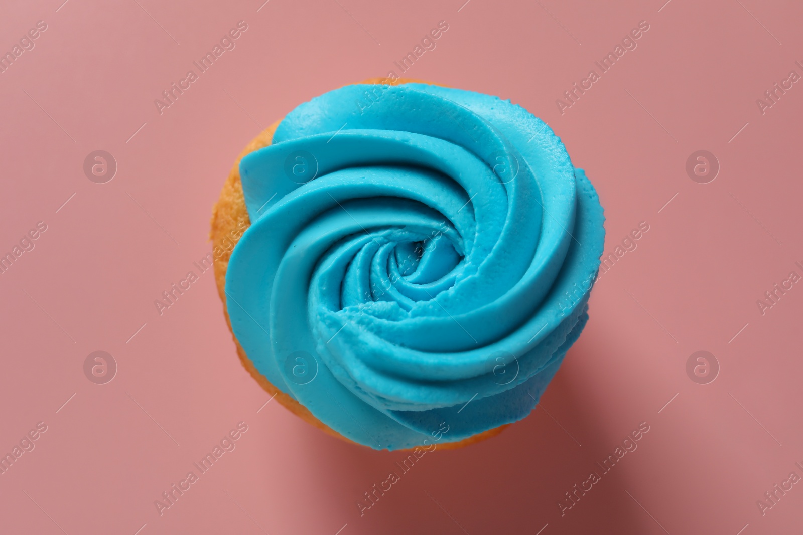 Photo of Delicious cupcake with bright cream on pink background, top view