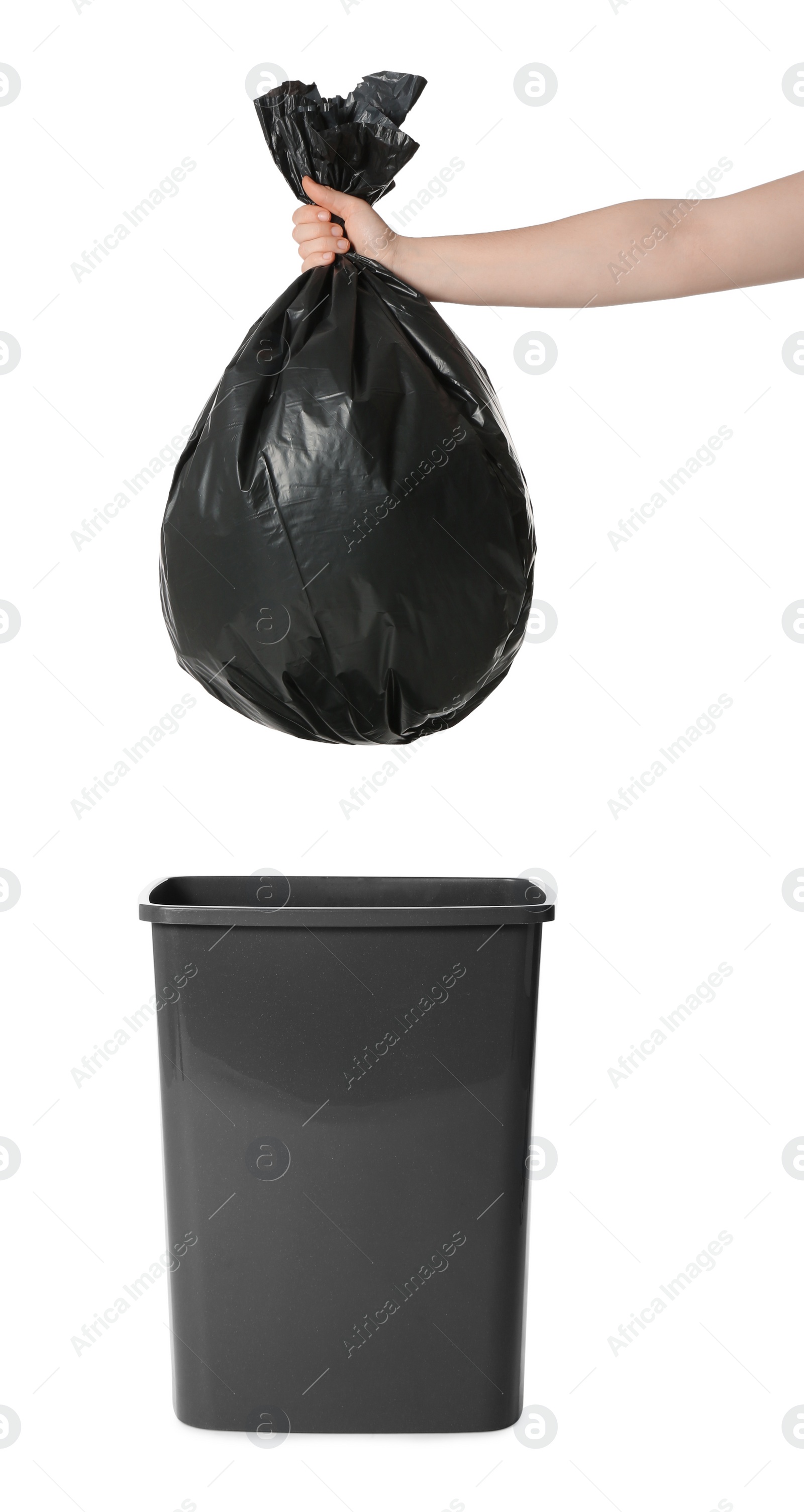 Photo of Woman holding trash bag full of garbage over bucket on white background, closeup