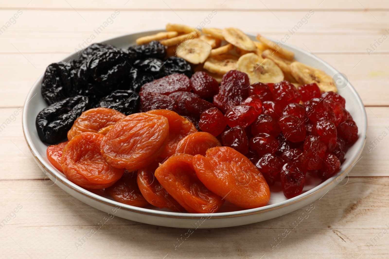 Photo of Delicious dried fruits on white wooden table, closeup