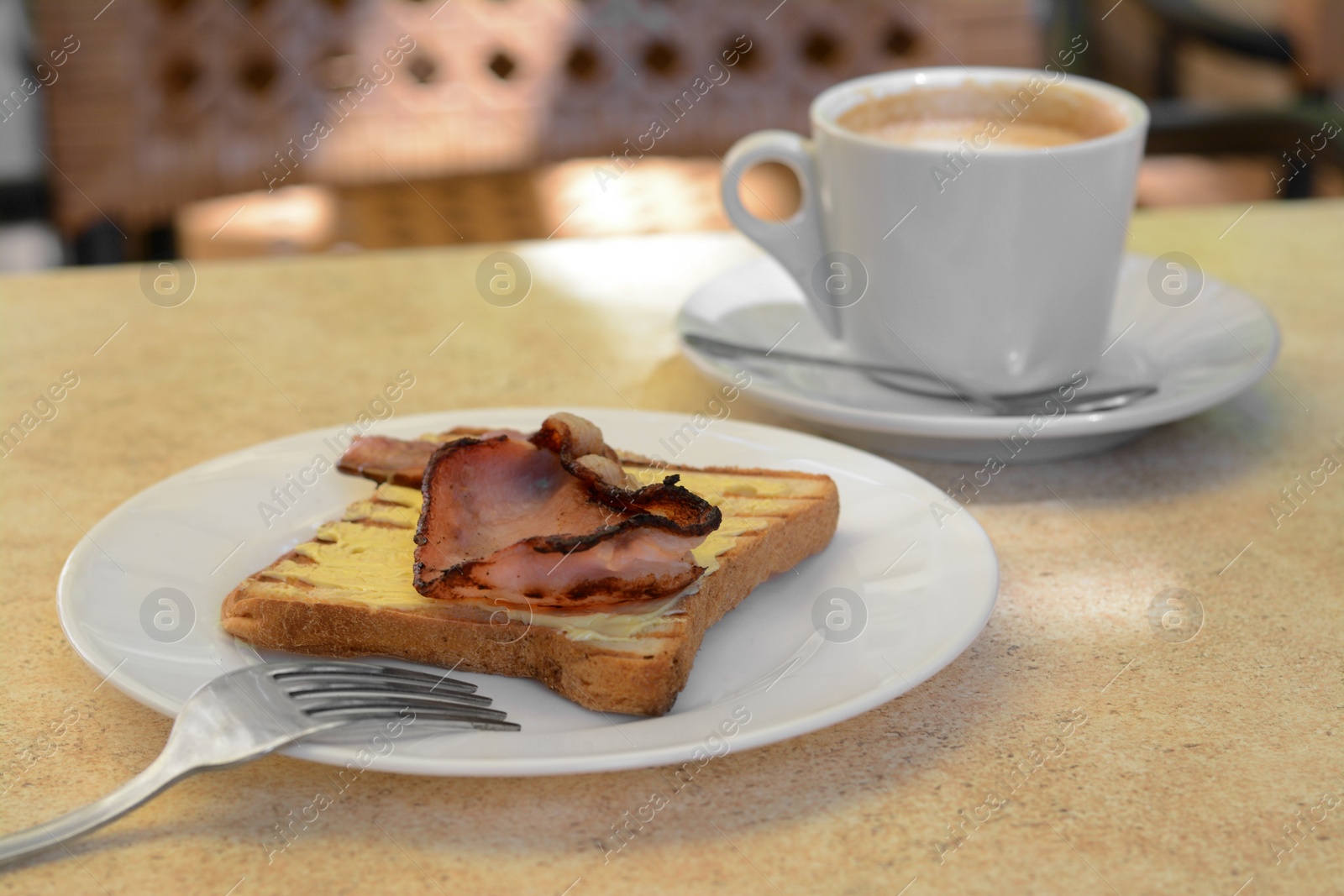 Photo of Cup of coffee and delicious sandwich with fried bacon on beige table