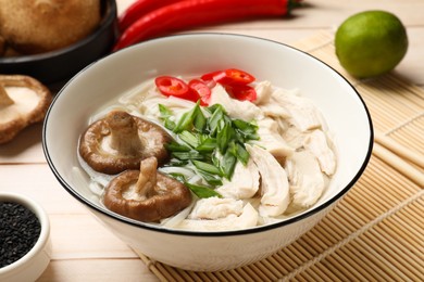 Photo of Delicious ramen with meat and ingredients on wooden table, closeup. Noodle soup