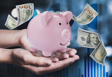 Image of Woman holding piggy bank and American dollars falling on color background, closeup 