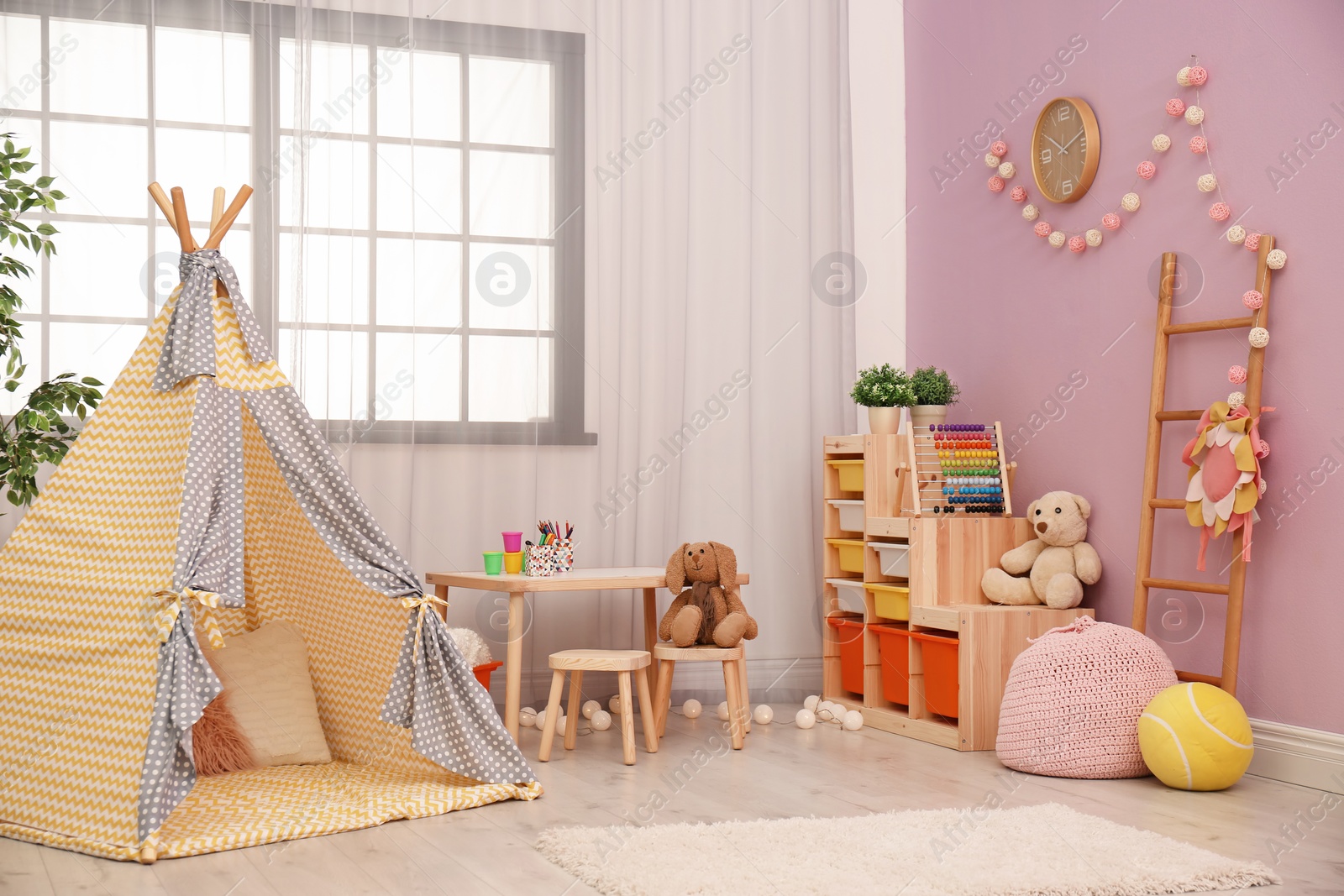 Photo of Modern nursery room interior with play tent for kids