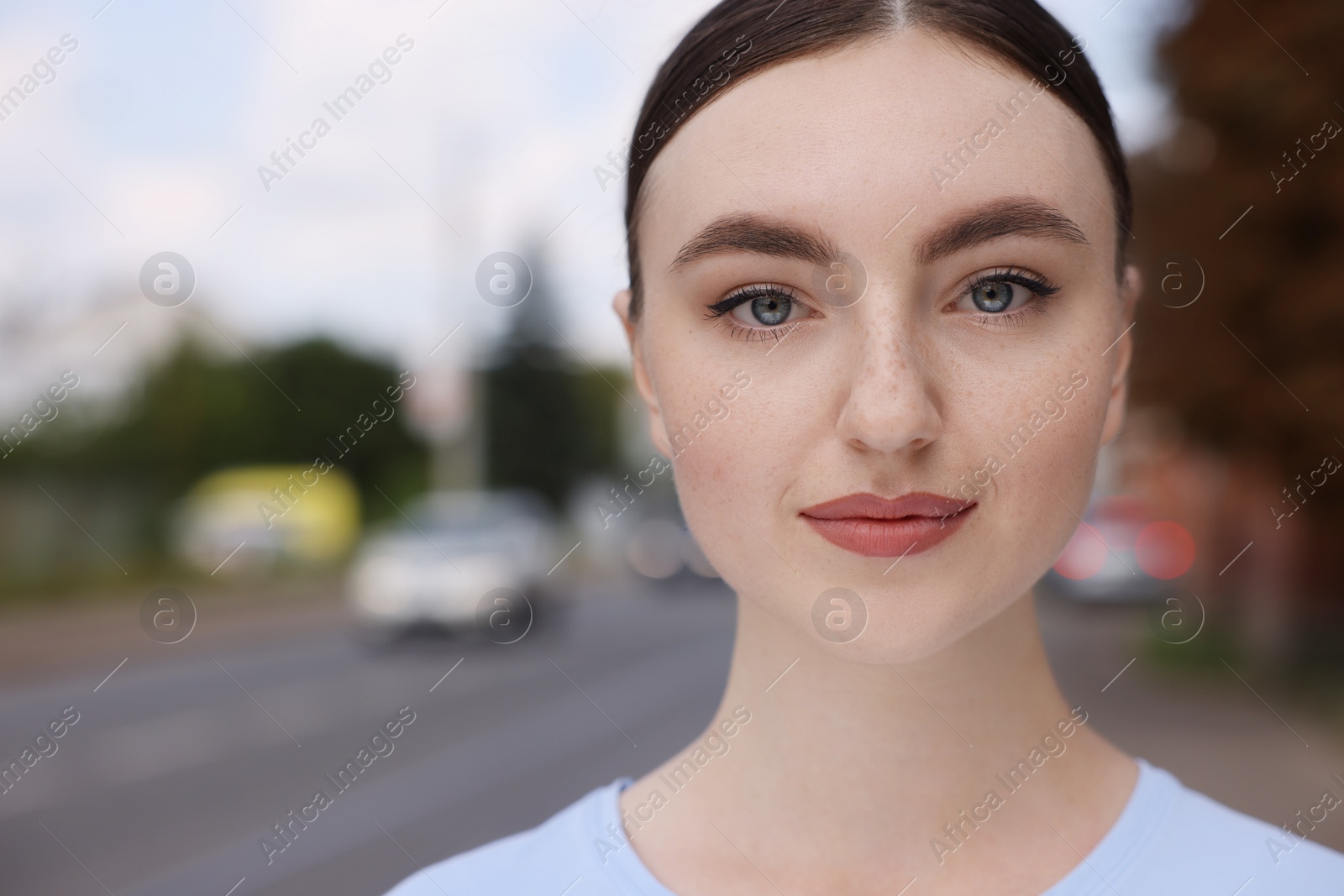 Photo of Portrait of beautiful woman looking at camera outdoors. Space for text