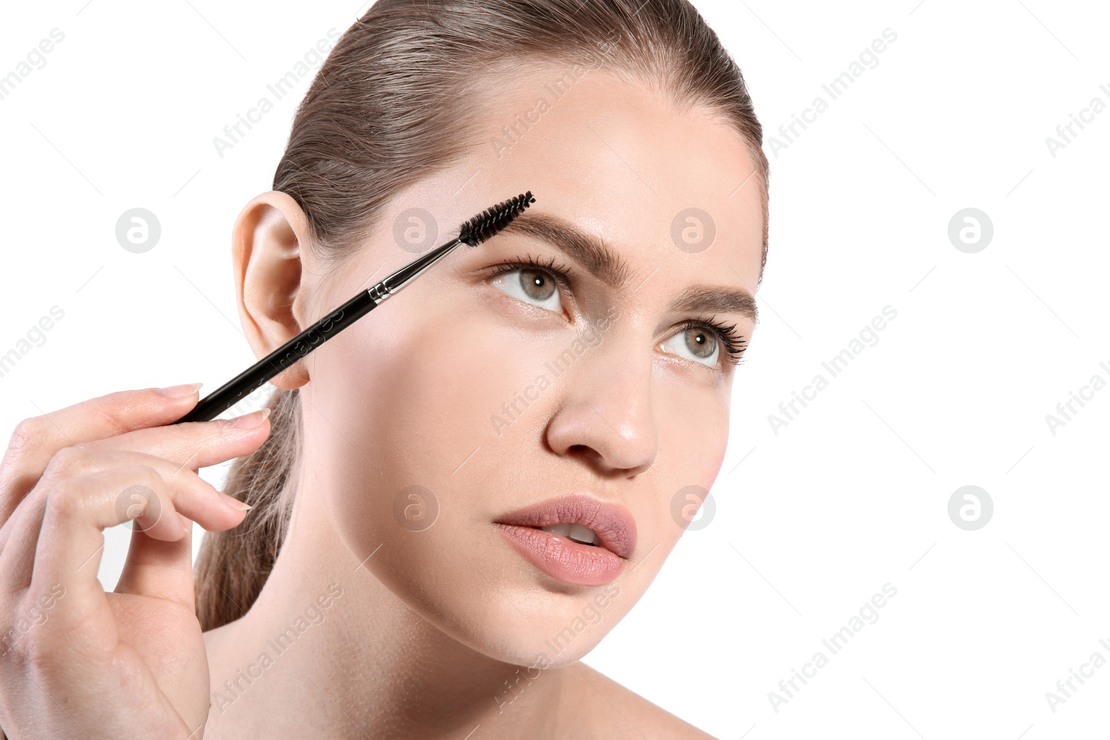 Photo of Beautiful woman with perfect eyebrows applying makeup on light background