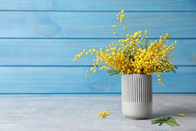 Bouquet of beautiful mimosa flowers on grey table