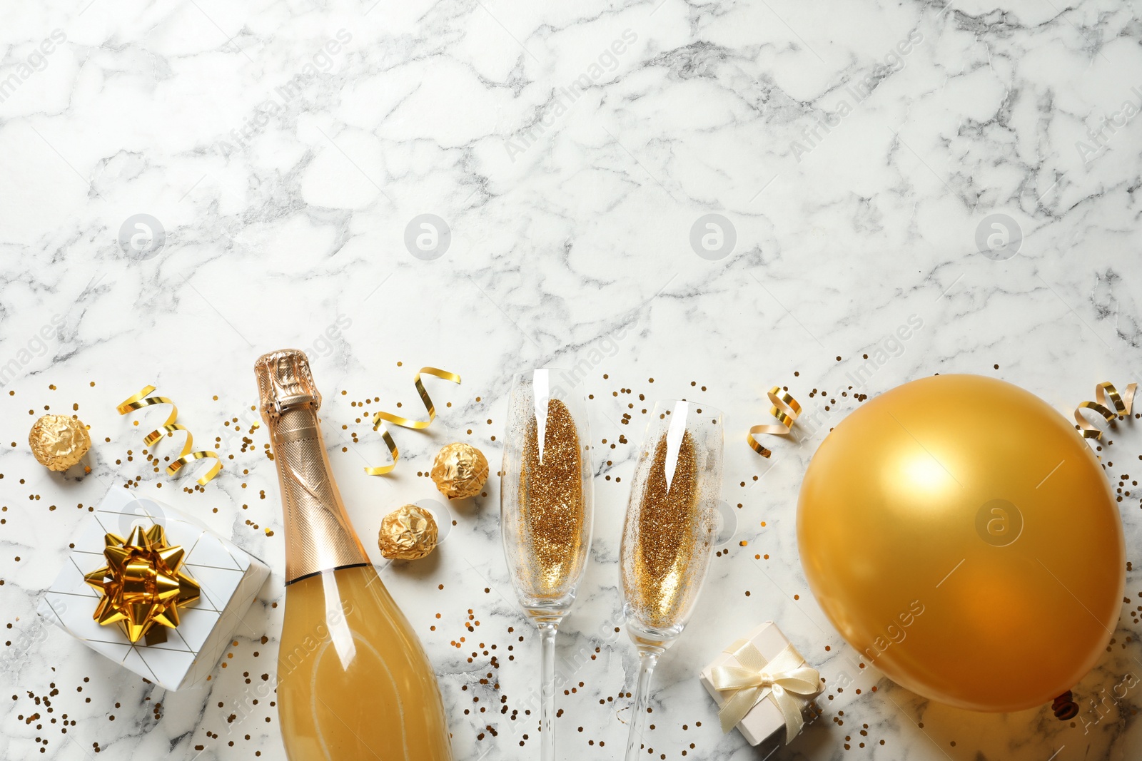 Photo of Flat lay composition with bottle of champagne for celebration on white marble background. Space for text
