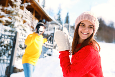 Photo of Happy couple playing snowballs outdoors. Winter vacation