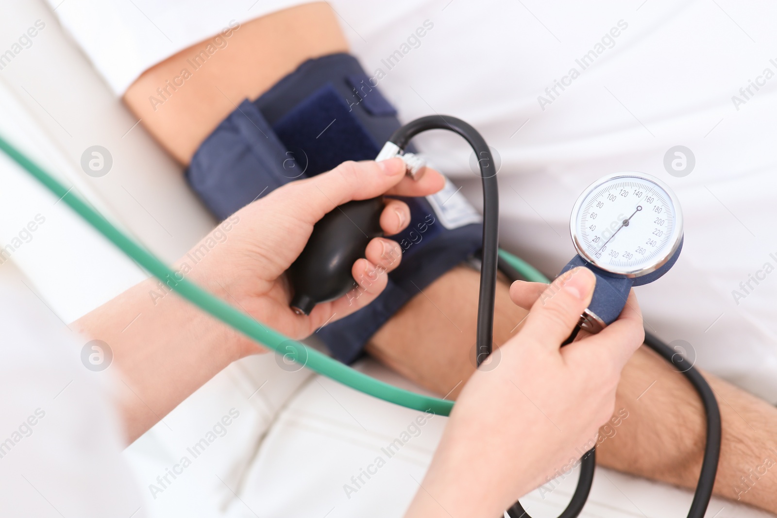 Photo of Doctor checking blood pressure of man in clinic, closeup