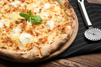 Image of Tasty cheese pizza on wooden table, closeup