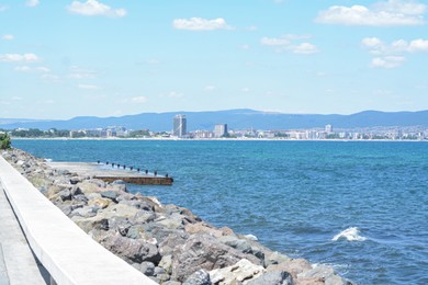 Beautiful view of coastal city and concrete pier on sunny day