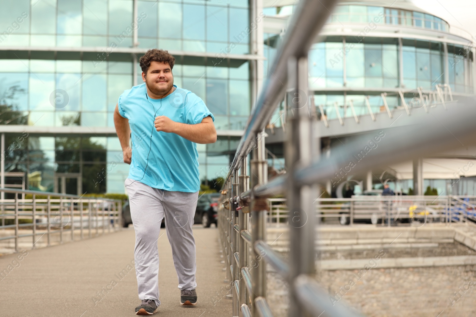 Photo of Young overweight man running outdoors. Fitness lifestyle