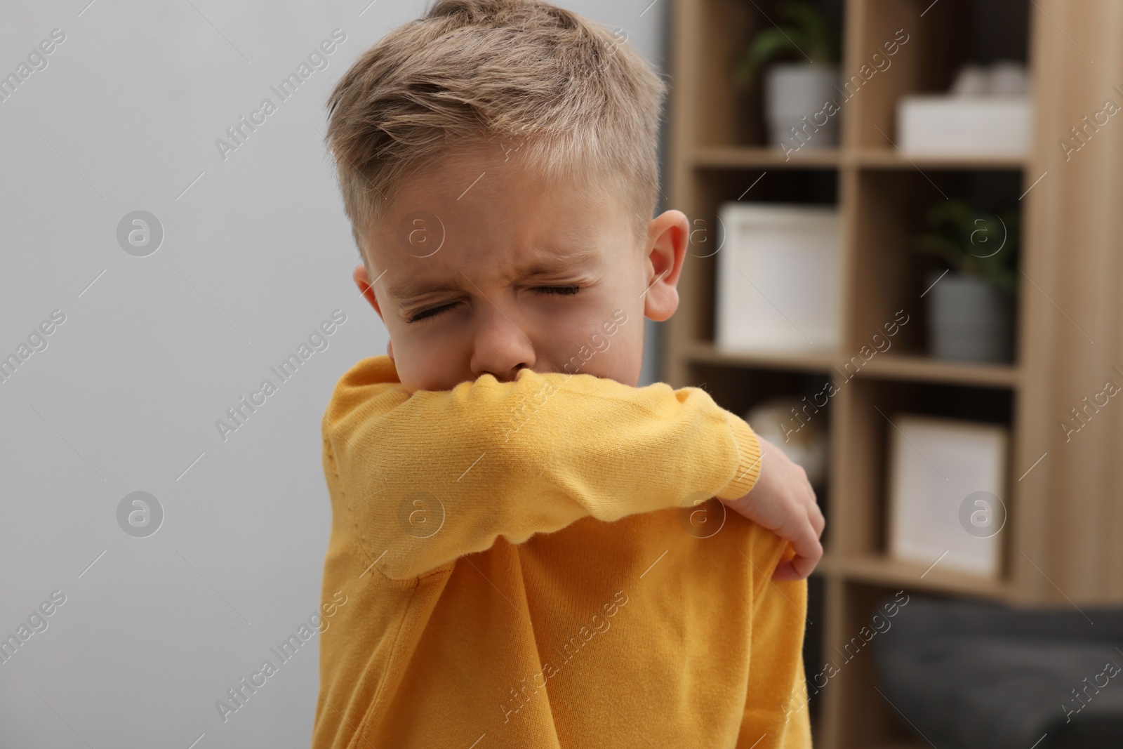 Photo of Sick boy coughing at home. Cold symptoms