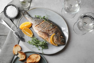 Seafood. Delicious baked fish served on grey textured table, flat lay