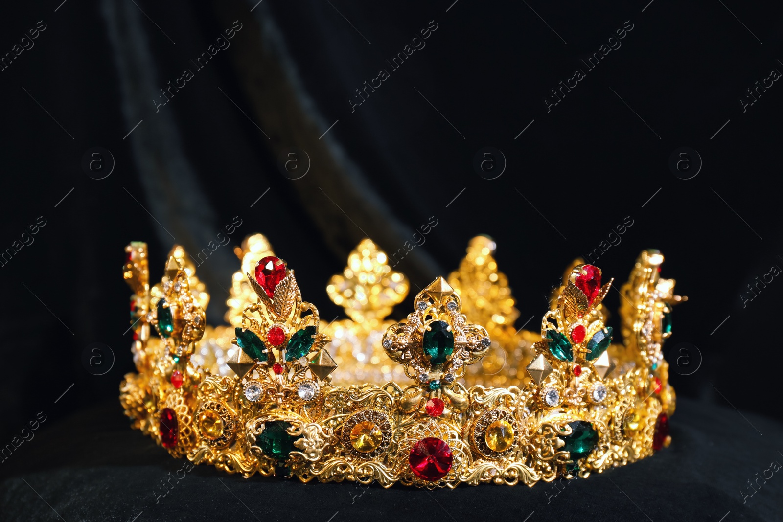 Photo of Beautiful golden crown on black fabric. Fantasy item