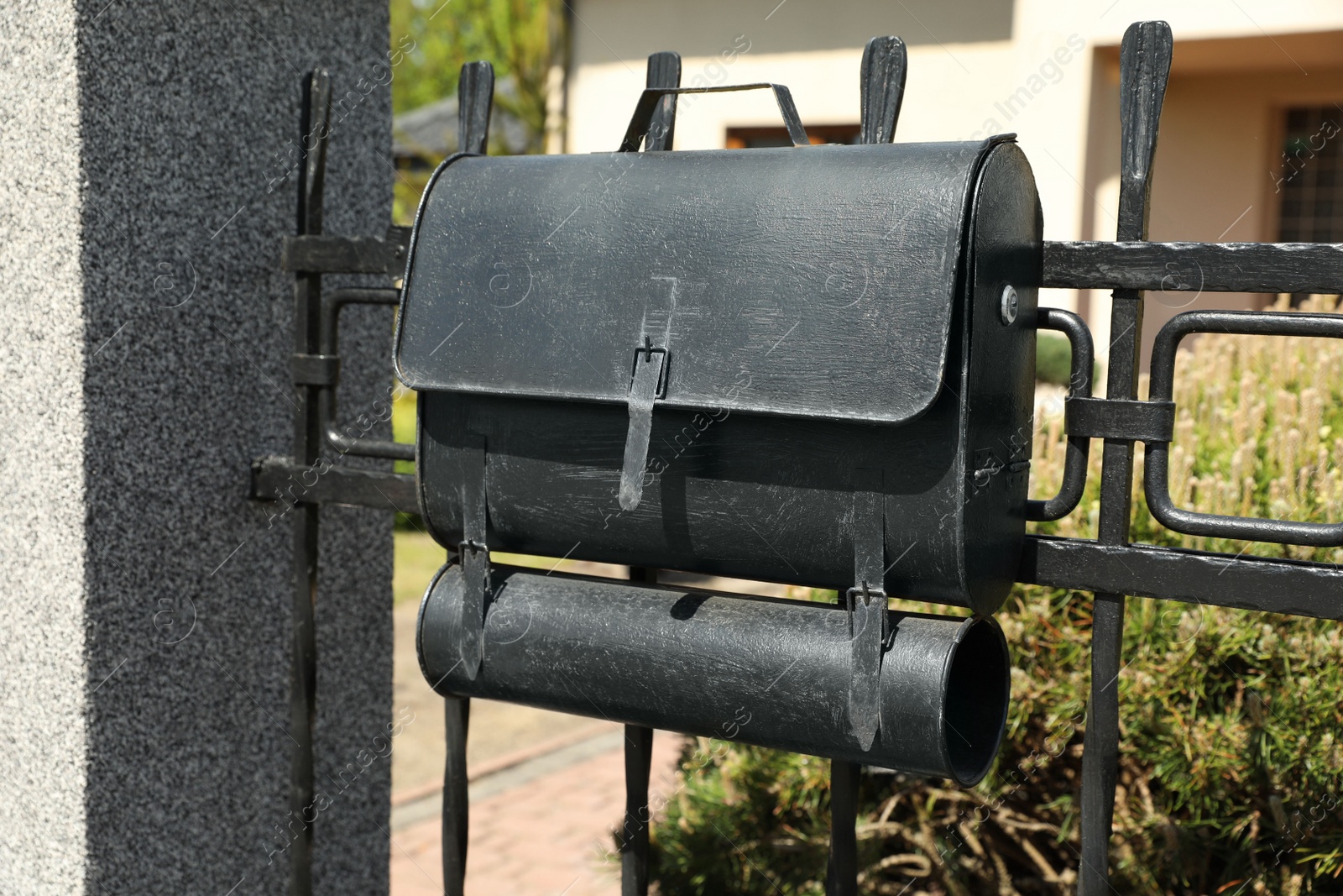 Photo of Black metal letter box on fence outdoors