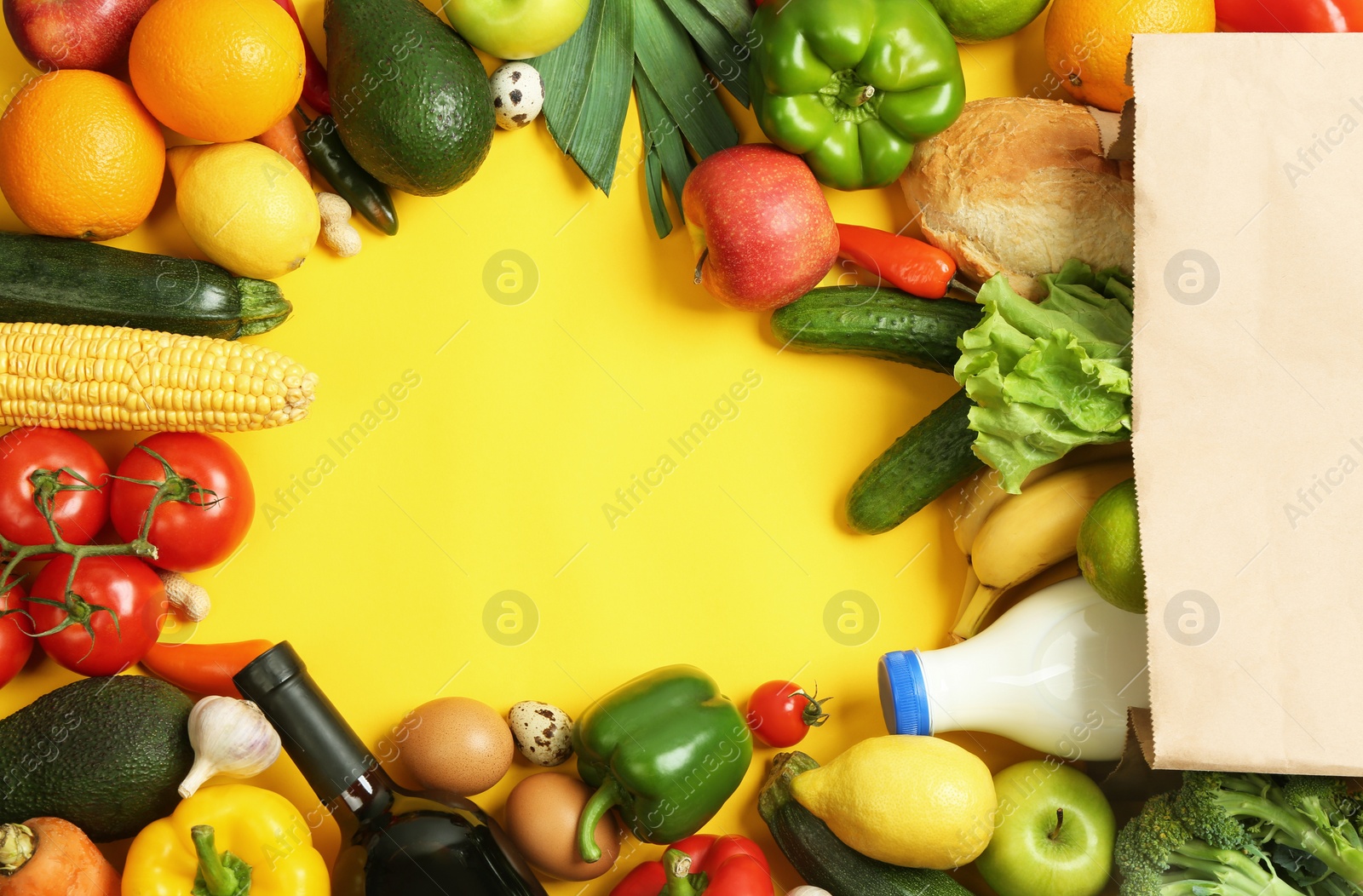 Photo of Paper bag with different groceries on yellow background, flat lay. Space for text