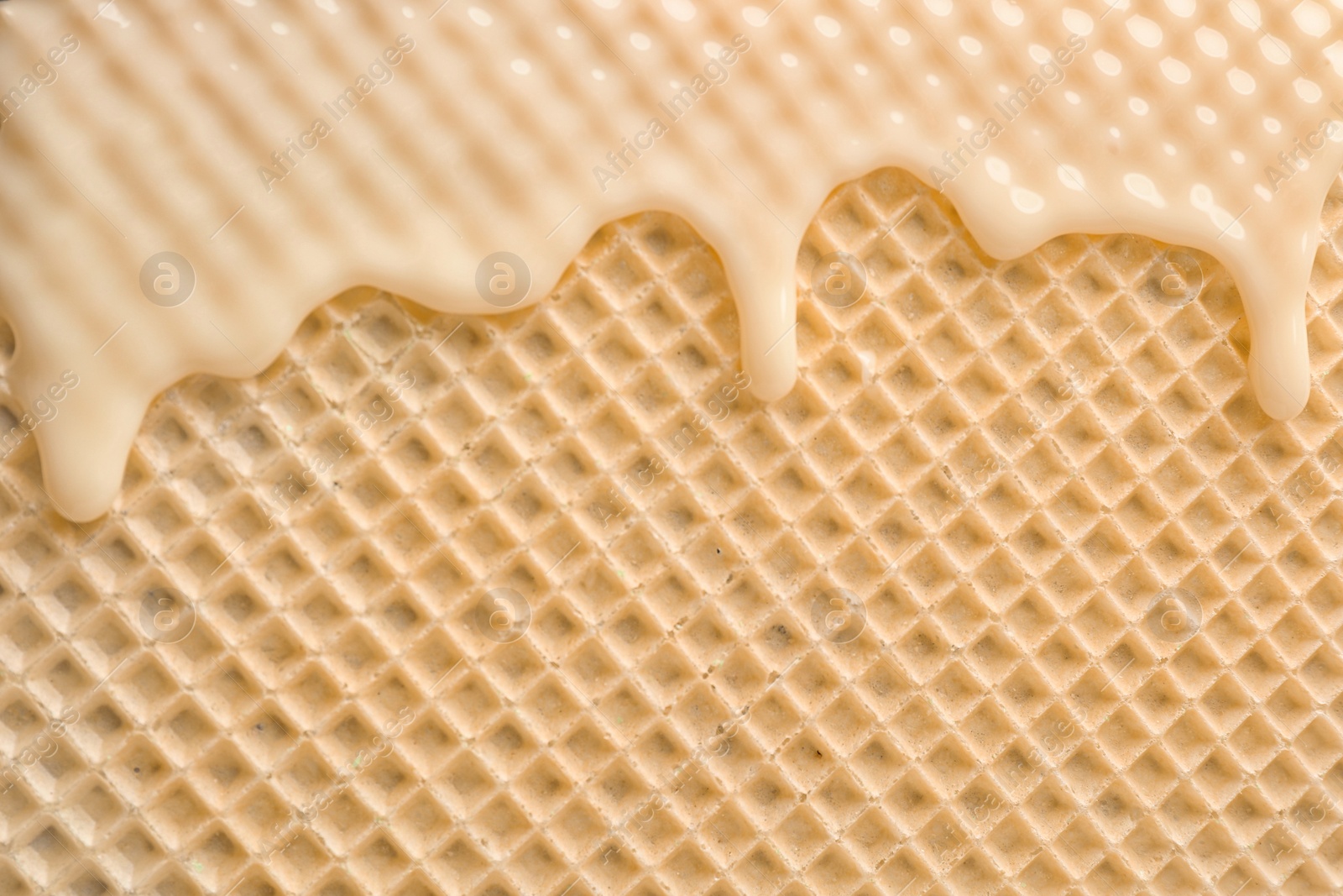 Photo of Hot white chocolate on wafer, closeup. Crispy food