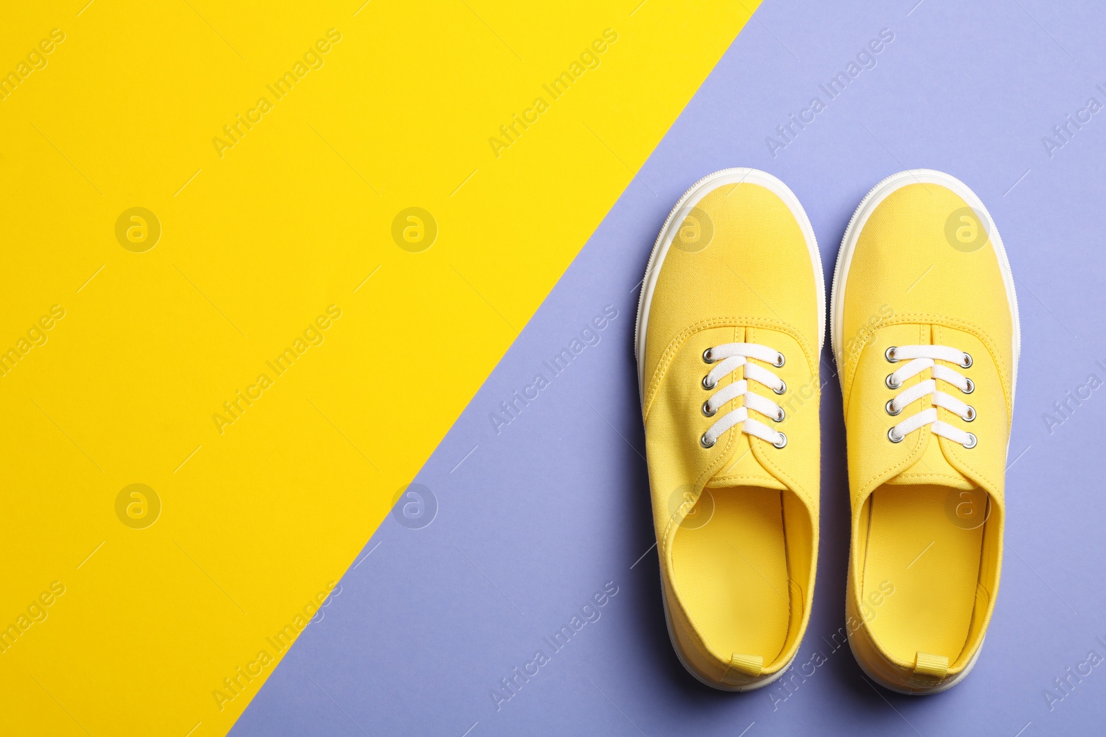 Photo of Bright stylish shoes on color background, top view. Space for text