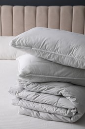 Soft folded blanket and pillows on bed indoors, closeup