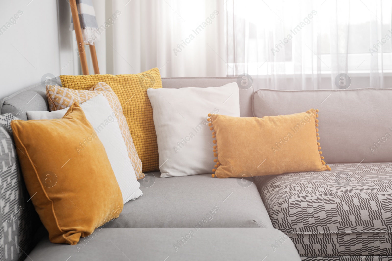 Photo of Comfortable sofa near window with stylish curtains in living room