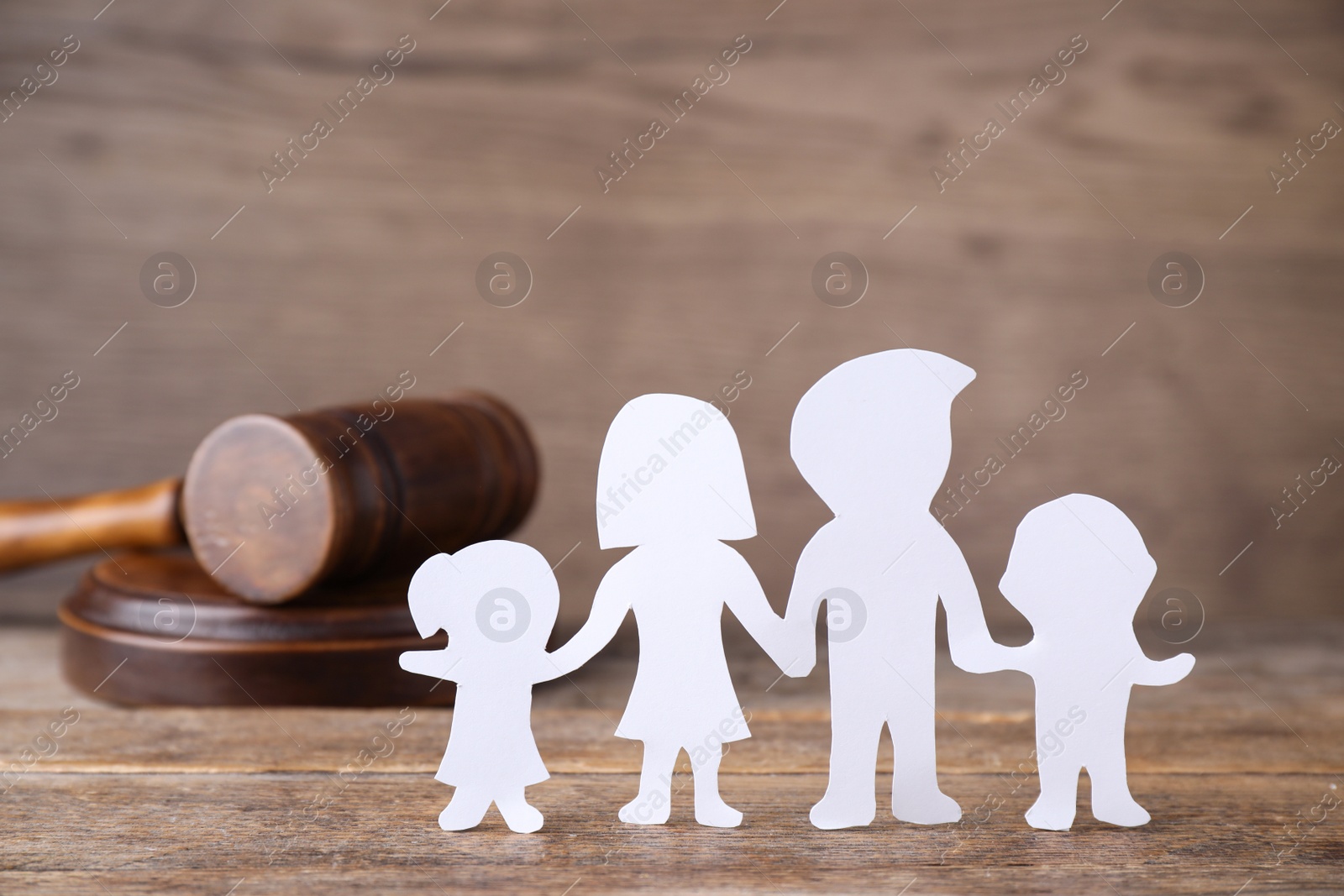 Photo of Figure in shape of people and gavel on wooden table. Family law concept
