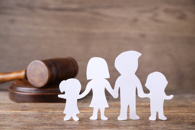 Photo of Figure in shape of people and gavel on wooden table. Family law concept