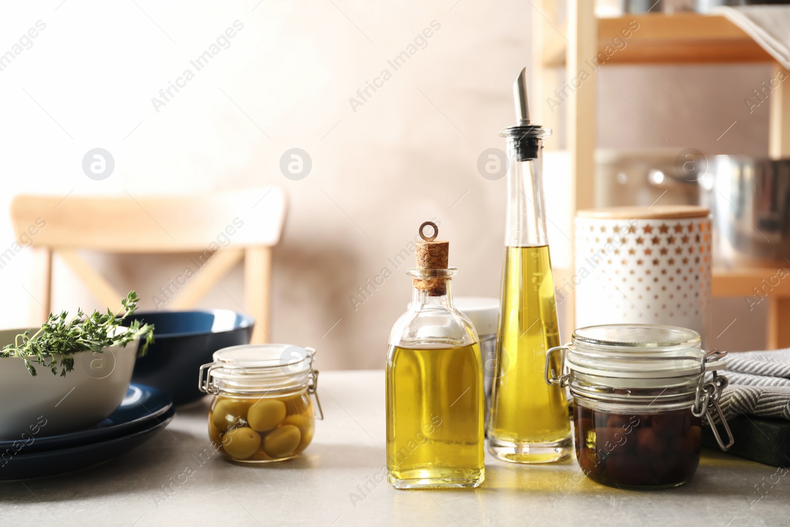 Photo of Fresh olive oil and kitchen utensils on table