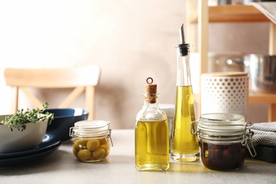 Photo of Fresh olive oil and kitchen utensils on table