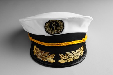 Photo of Peaked cap with accessories on light grey background
